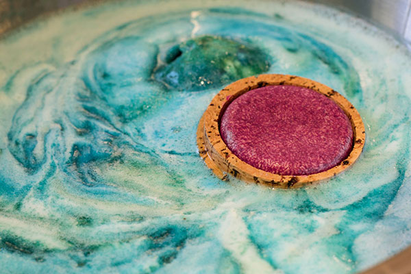 Bild: Eine Aufbewahrungsmöglichkeit für Haarshampoo aus Kork? Auch noch mit einem altmodischen Segelschiff transportiert? Und CO₂-neutral? Wer macht denn so was?