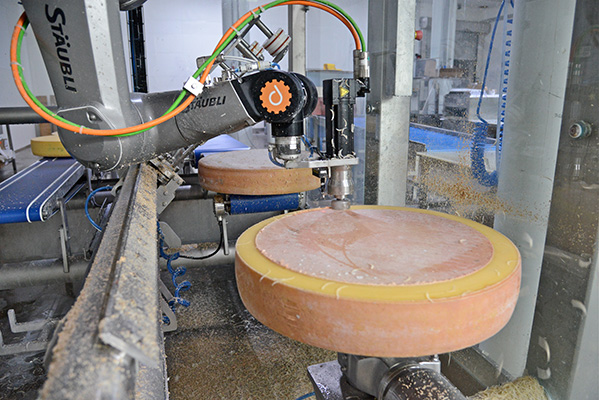 Bild: In einer Tiroler Biokäserei entrindet und bestreicht ein Sechsachser von Stäubli unregelmäßig geformte Käselaibe. Der TX2-90 he widersteht dauerhaft Intensivreinigungen ...